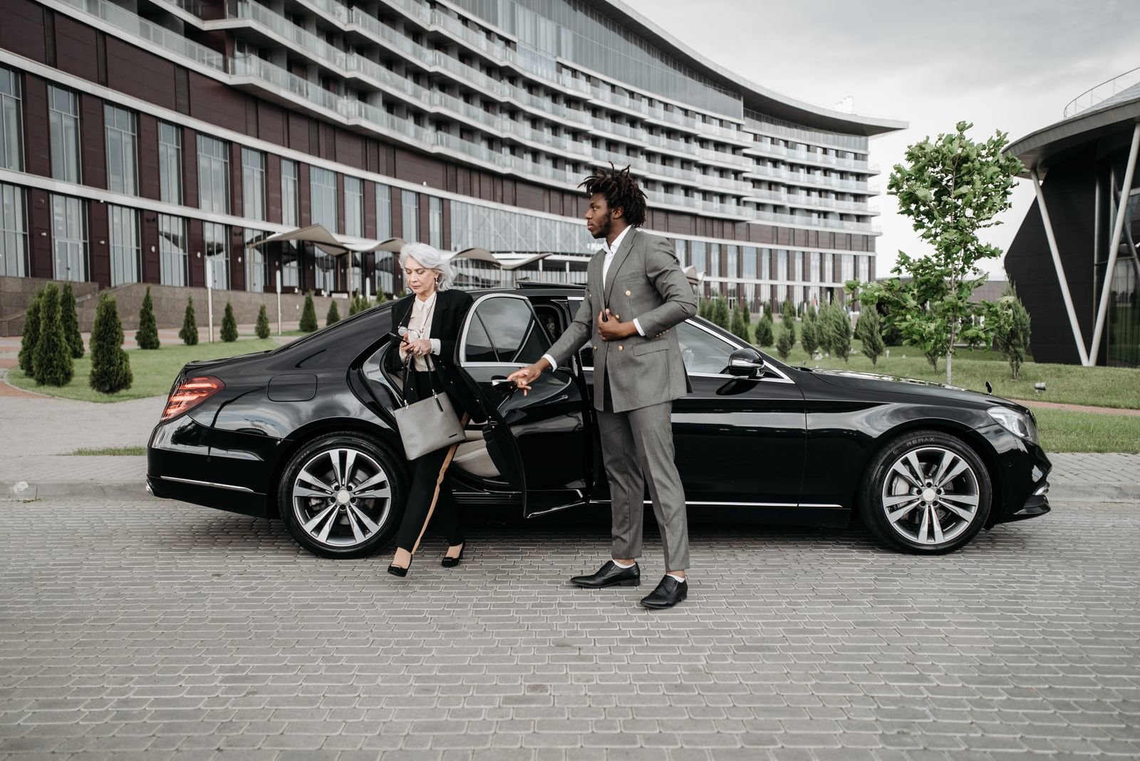Chauffeur hält die Autotür für einen Fahrgast auf – Chauffeur Service Frankfurt